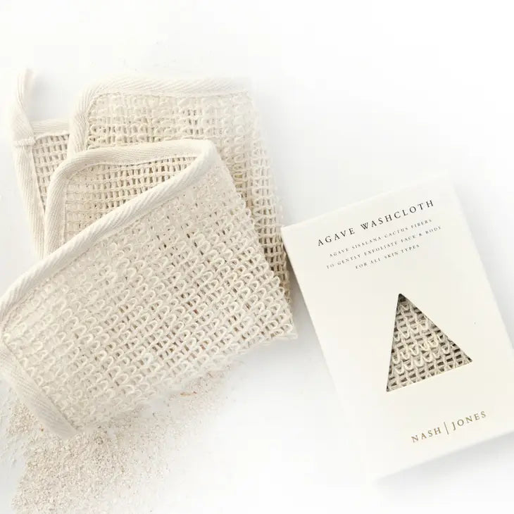 Three agave fiber washcloths stacked beside their packaging box labeled "agave washcloth" by nash jones, displayed on a plain white background.